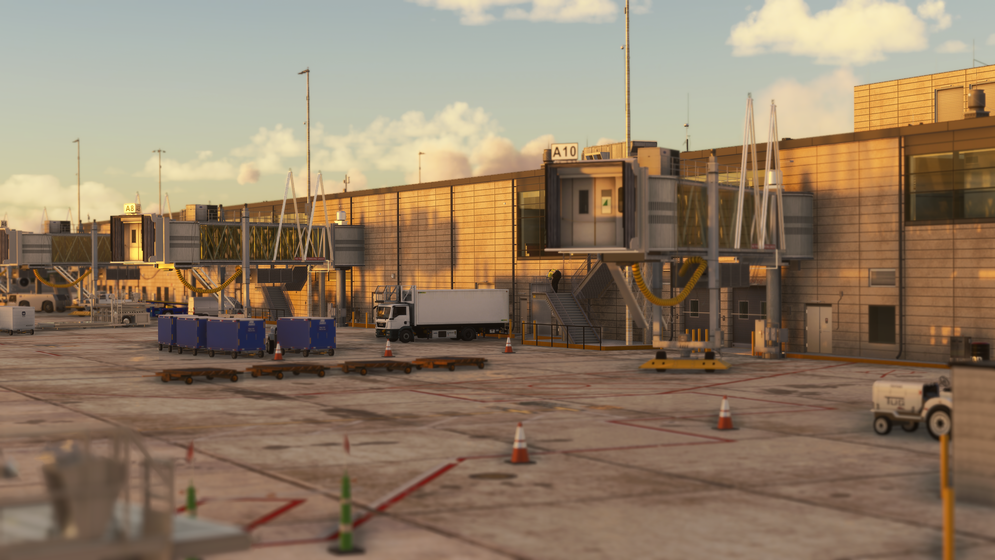 Kansas City International Airport terminal apron with jet bridges and ground service vehicles at sunset